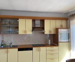eine Küche mit weißen Schränken und einer Spüle in der Unterkunft Konak u Gradini in Tomislavgrad