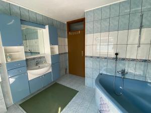 ein Badezimmer mit einer blauen Badewanne und einem Waschbecken in der Unterkunft Konak u Gradini in Tomislavgrad