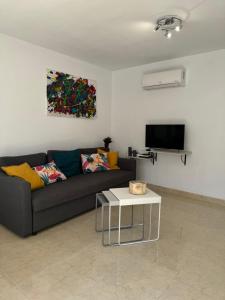 a living room with a couch and a table at El cosy de Portman in Portman