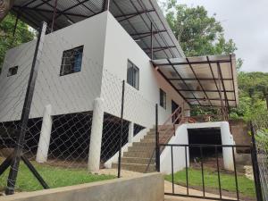 a white building with a fence in front of it at La Table de Apoyo in Masaya