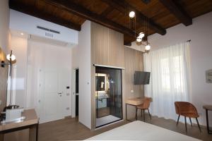 une chambre avec un lit, un bureau et une table dans l'établissement Heraklean Suites Tropea, à Tropea