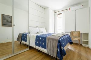 a bedroom with a bed with a blue comforter at Aconchego na Frei Caneca, Shopping/Beiramar UQ2910 in Florianópolis +16 photos