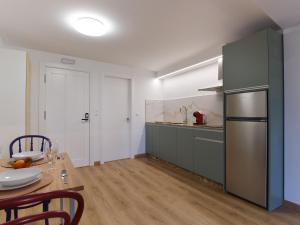 a kitchen with a table and a stainless steel refrigerator at V11apartamentos 4 in Archidona