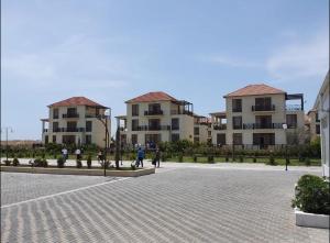 a group of buildings with people walking in a courtyard at Buzovna Delmar Luxury Residence in Mərdəkan