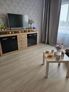 a living room with a tv and a coffee table at JJ apartment in Jelgava