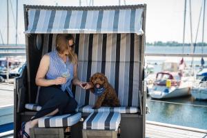 a woman sitting in a chair with a teddy bear at Hausboot ELLA- Huus & Meer in Burgstaaken