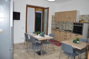 a kitchen with two tables and chairs in a room at Bed and breakfast Bell'aria in Desulo
