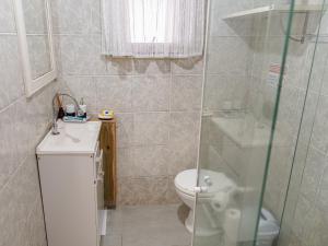 ein Badezimmer mit Toilette und Glasdusche in der Unterkunft Unidade do térreo: casa à beira mar XJ6722 in São Francisco do Sul + 18 Fotos