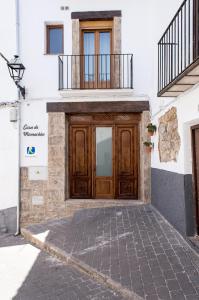 a building with a wooden door with a balcony at Casa de Mamachon in Cazorla