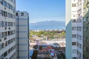 a view of the ocean from between two buildings at Aptos modernos no centro de Floripa - VLR in Florianópolis
