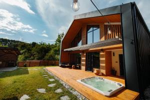 a house with a hot tub on a wooden deck at True Cabin in Sovata