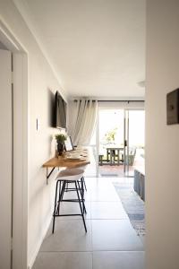 a kitchen and dining room with a table and a desk at Ocean Whisper Unit 79 in Hermanus