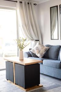a living room with a blue couch and a table at Ocean Whisper Unit 79 in Hermanus