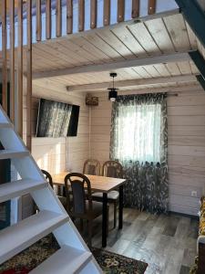 a dining room with a wooden table and chairs at Aframe Shanti DreamDim in Svityazʼ