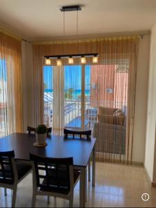 a dining room with a table and chairs and a couch at Magnífico piso con vistas al mar en Moncofa in Moncófar