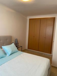 a bedroom with a bed and a large cabinet at Magnífico piso con vistas al mar en Moncofa in Moncófar