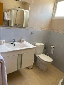 a bathroom with a sink and a toilet and a mirror at Magnífico piso con vistas al mar en Moncofa in Moncófar