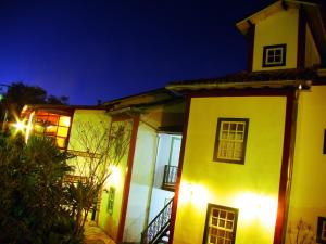 a white house with lights on it at night at Pousada Villa Verde in Lavras Novas