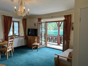 a living room with a bed and a television and a table at Seerose in Kochel