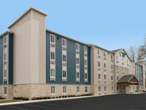 an apartment building with a blue and gray building at WoodSpring Suites Richmond Airport in Henrico