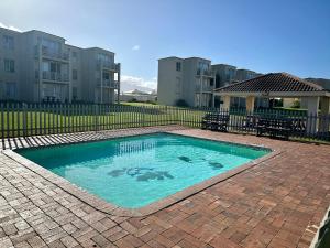 a swimming pool in front of some apartment buildings at Ocean Whisper Unit 79 in Hermanus