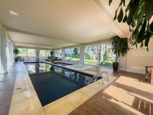 Una piscina cubierta en una casa grande con ventanas de cristal. en Casa de Pedra 2 Suítes e Piscina by Achei Gramado, en Gramado