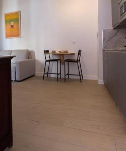 Una sala de estar con mesa y sillas y una cocina. en V11apartamentos 2, en Archidona