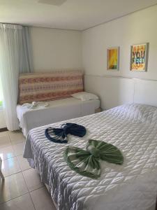 ein Schlafzimmer mit zwei Betten mit Bögen darauf in der Unterkunft Club Meridional Carneiros in Tamandaré + 65 Fotos
