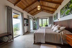 a bedroom with a large bed and a large window at Villas Jawara ! Un Volcán en su Jardín ! in Fortuna +269 photos