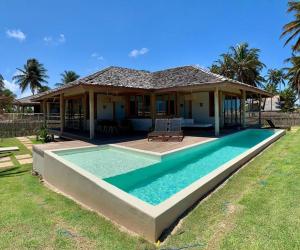 ein Haus mit einem Swimmingpool vor dem Haus in der Unterkunft Casa do vento - Ilha do Guajiru in Itarema