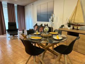een woonkamer met een glazen tafel en stoelen bij Apartamento Nuria,Centro del Pueblo,Planta baja con jardin, Aire Acondicionado in L'Escala