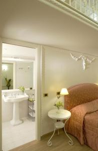 Un dormitorio con una cama y un lavabo y un baño. en Suites Rome, en Roma 80 fotos más