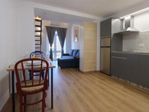 a kitchen and living room with a table and a couch at V11apartamentos 3 in Archidona