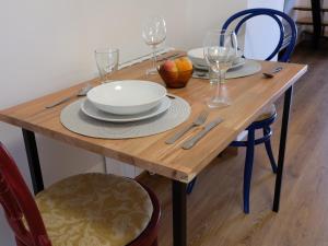 a wooden table with plates and wine glasses on it at V11apartamentos 3 in Archidona +2 photos