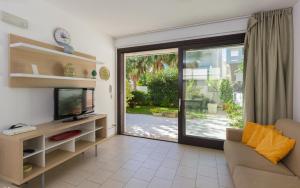 a living room with a tv and a sliding glass door at Kamena Residence in Marina di Ragusa