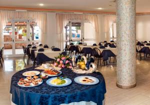 a table with plates of food on it in a restaurant at Hotel Alizé in Santa Cesarea Terme