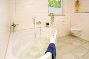 a bathroom with a bath tub and a toilet at Blinkfüer in Nordhorn