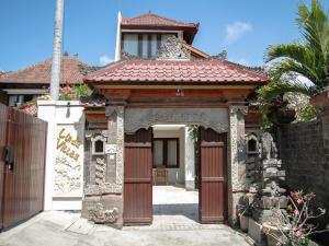 una casa con una puerta y una valla en Linda Villa Sanur, en Sanur