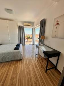Un dormitorio con una cama y un escritorio y una ventana. en Alfarim House - close to Meco beach and Sesimbra, en Sesimbra 33 fotos más