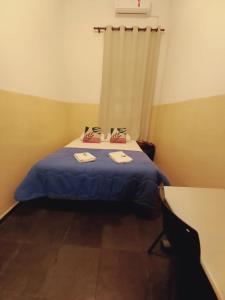 a bedroom with a bed with blue sheets and a window at Hotel Central in Araçatuba +22 photos