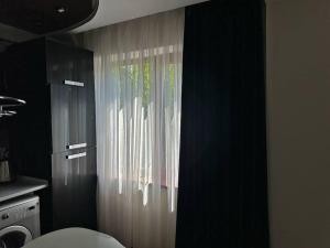 a bathroom with a shower curtain in a kitchen at Уютная квартира , с удобствами in Taraz