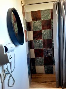 a mirror and a camera in a room with a tiled wall at Apartments Alavana in Velipojë +25 photos