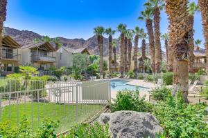 a home with a pool and palm trees at Balcony and Views Pet-Friendly Indian Wells Unit in Indian Wells