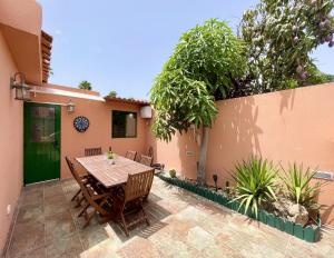 a patio with a wooden table and chairs at Ten-Beau Relax Bungalow in Maspalomas