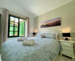a bedroom with a large bed and a window at Ten-Beau Relax Bungalow in Maspalomas +33 photos