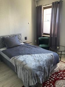 a bedroom with a bed and a chair and a window at Time-Out Westerbauer TC15B in Hagen