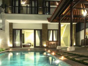 a swimming pool in front of a villa at Linda Villa Sanur in Sanur