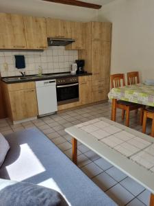 a kitchen with wooden cabinets and a table and chairs at Ferienhof Bisdorf "Schwülkennest" Reihenhaus in Bisdorf