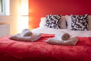 a bed with two towels on top of it at 2 Bedroom Beautiful Apartment in Motherwell in Mossend