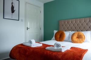 a bedroom with a bed with two towels on it at 2 Bedroom Beautiful Apartment in Motherwell in Mossend